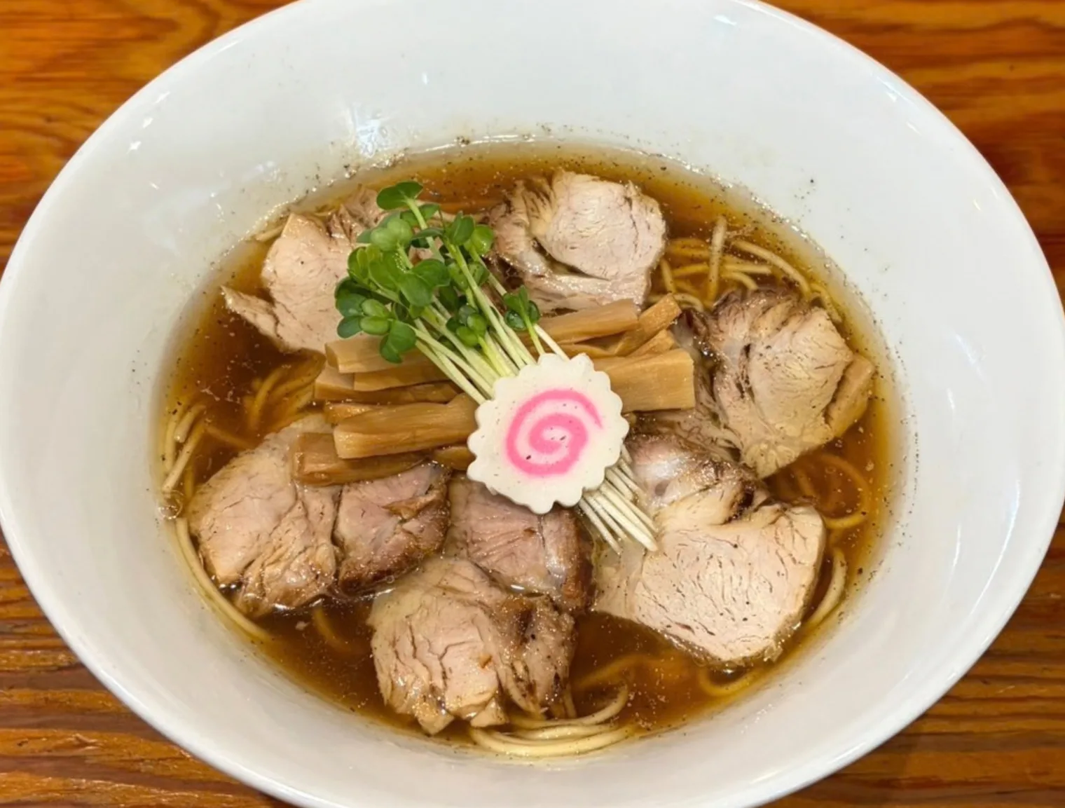 澄んだスープにチャーシュー、メンマ、なると、かいわれを盛り付けた中標津中華そば